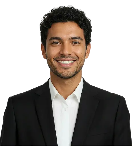 Jovem vestindo terno preto, camisa social e óculos de grau sorrindo em fundo neutro.