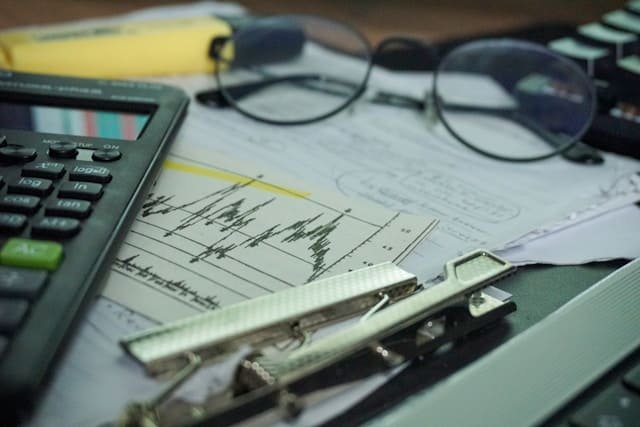 óculos sobre documentos fiscais complexos, simbolizando auditoria fiscal e recuperação de valores.